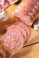 Headcheese on wooden cutting board, top view. Brawn. Pork cold cuts.
