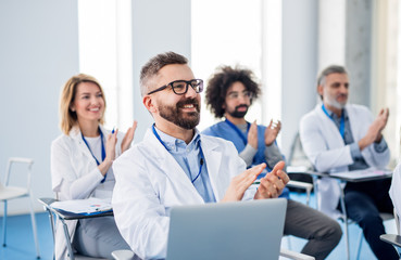 Group of doctors listening to presentation on medical conference.