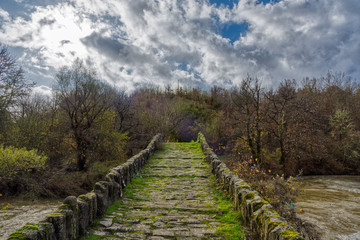 Green stone bridge over autumn landscape