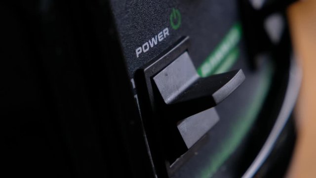 Somebody turn switch on the power button on an electrical device