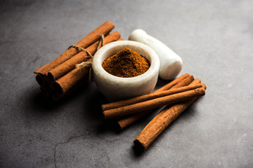 Powder cinnamon and sticks also known as Dalchini or Dalcheenee masala from India, selective focus