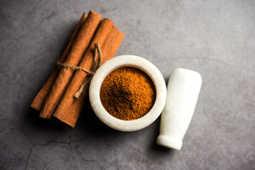 Powder cinnamon and sticks also known as Dalchini or Dalcheenee masala from India, selective focus