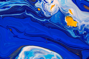 Fluid art texture. Backdrop with abstract swirling paint effect. Liquid acrylic picture that flows and splashes. Mixed paints for website background. Blue, golden and white overflowing colors