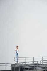 Short haired redhead young woman lies on railing in urban center in hot summer day