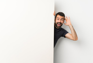 Young handsome man with beard holding a big empty placard