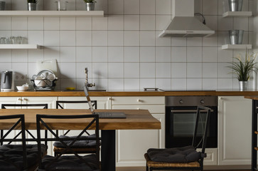 Close Up of laptop on kitchen counter with kitchen on background.