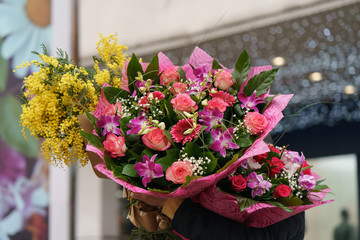 Photography of bouquets of spring flowers on the city market (pink roses and yellow mimosa). Festive mood. Holidays concepts. International women's day, March 8.