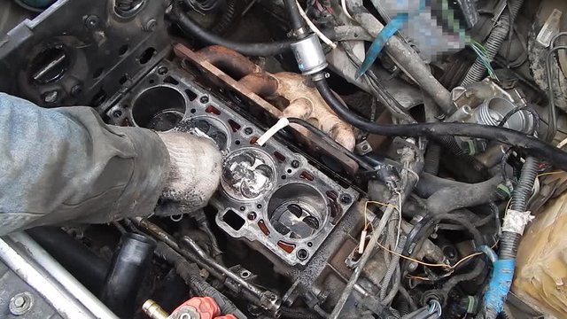 Engine cylinder block. Cleaning the pistons from carbon deposits.