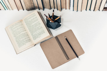 Notebook, pencils, glasses and stack of books, school background for education learning concept.