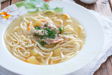 Homemade chicken soup with homemade egg noodles, horizontal