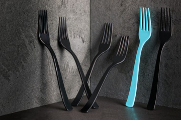 Minimalistic elegant, black forks and one turquise on black background