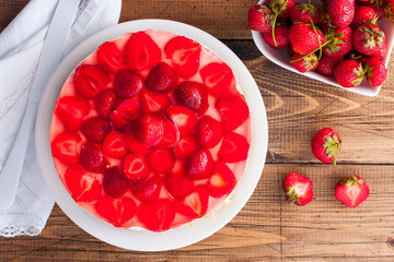 Cheesecake without baking with strawberries on a wooden table, top view, horizontal, copy space