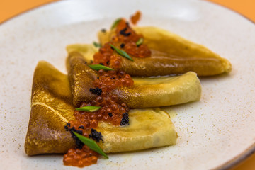 Fried pancakes in oil with red caviar
