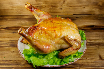 Baked whole chicken on a wooden table