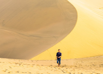 Fototapeta na wymiar Young man walks the edge of dune