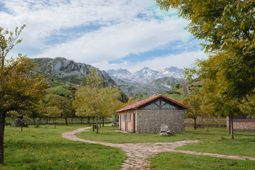 Beautiful cabin surrounded by trees and mountains on a sunny day in Asturias, Spain