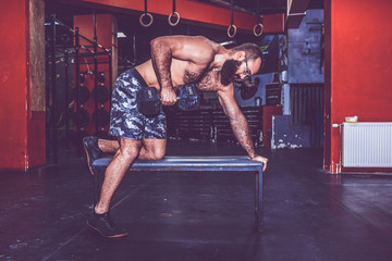 Young man doing exercises with dumbbell.