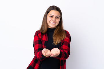 Teenager girl over isolated white background holding copyspace imaginary on the palm to insert an ad