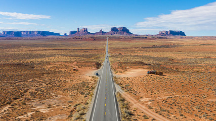 Obraz premium Aerial view of straight steet going towards the spectacular stone towers of Monument Valley in winter