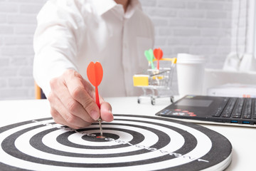 Fototapeta na wymiar Holding a darts aiming at the target center business goal concept,to target marketing ,