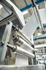 A industrial commercial envelope making machine, making paper envelopes for international distribution. Automated engineering machinery for mass production of paper envelopes.