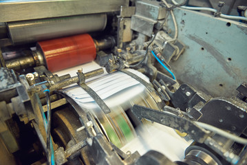 A industrial commercial envelope making machine, making paper envelopes for international distribution. Automated engineering machinery for mass production of paper envelopes.