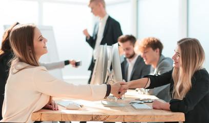 young employees shaking hands at a successful presentation