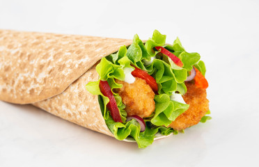 Wrap with fried chicken and vegetables isolated on a white background