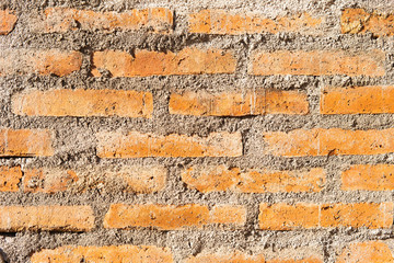 red brick wall glued with gray cement