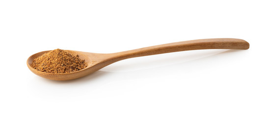 Nutmeg powder in wood spoon on white