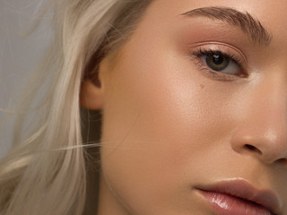 Closeup of half beauty woman with clean skin and natural cosmetics. Beautiful extrem eyelash and full lips of well-groomed girl demonstrate spa procedures, injections in a beauty parlor. Blonde hair