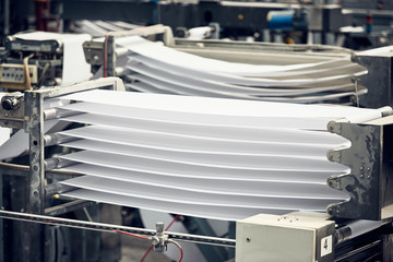 A toilet paper making machine producing toilet and bathroom paper rolls. Paper and tissue manufacturers factory and engineered machinery. Mass produced bathroom products.