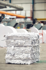 A paper recycling factory plant shredding machine, shredding waste paper into square bails, ready...