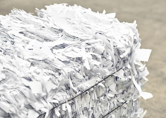 A paper recycling factory plant shredding producing waste paper into square bails, ready to be...