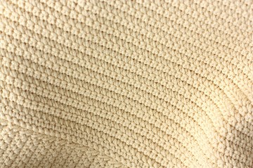 Fototapeta na wymiar Beautiful beige knitted fabric close up view 