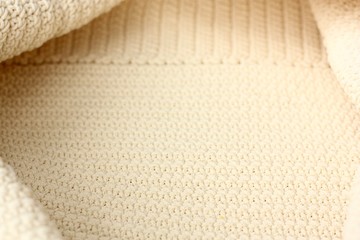 Beautiful beige knitted fabric close up view 