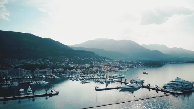 Top view on the marina with yachts near the coastline and the city surrounded the mountscape