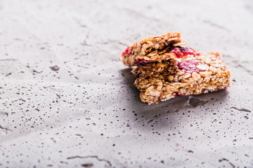 Muesli bar cut in half on a gray concrete background