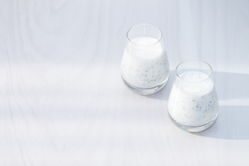 Healthy vanilla chia pudding on white wooden background. Morning, sunlight. Copy space.