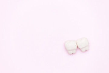 White tooth, space for text on color pink background. Healthy dental teeth concept.