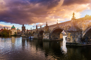 Obraz premium Autumn view to Charles bridge on Vltava river in Prague, Czech Republic. Autumn view to Charles Bridge, Prague old town and Vltava river. Czechia. Scenic autumn view of the Old Town with red foliage.