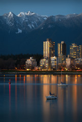 Vancouver West End Dusk. Sailboats anchored in English Bay. In the background are the snowcapped North Shore Mountains. Vancouver, British Columbia, Canada.