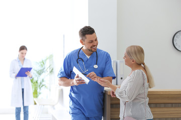 Doctor talking with patient in hospital hall