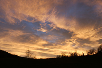 shades of clouds in sunset sky on the hills