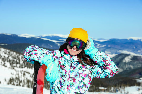 Young woman with ski equipment in mountains. Winter vacation