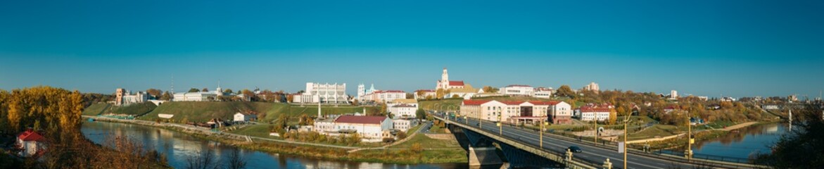 Fototapeta premium Grodno, Belarus. Grodno Regional Drama Theater And Catholic Church Of Discovery Of Holy Cross And Bernardine Monastery In Sunny Autumn Day. Panorama, Panoramic View. Skyline Cityscape
