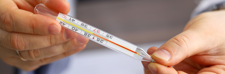 Male doctor holding in hand thermometer