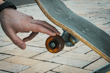 close up of hand touching skateboard wheel