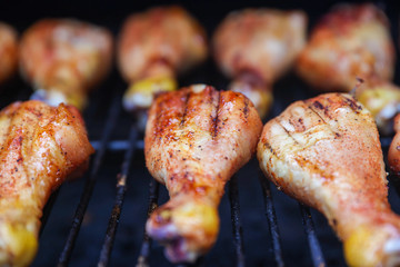 Chicken leg cooking on barbecue grill