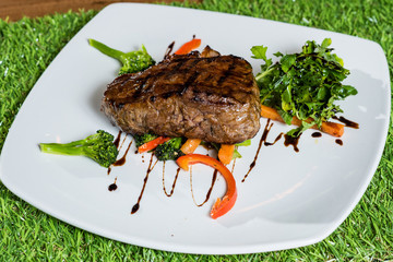 Steak on white plate with garnish